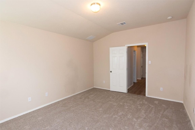 carpeted empty room with lofted ceiling