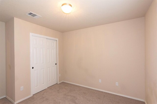 unfurnished bedroom featuring a closet and carpet flooring