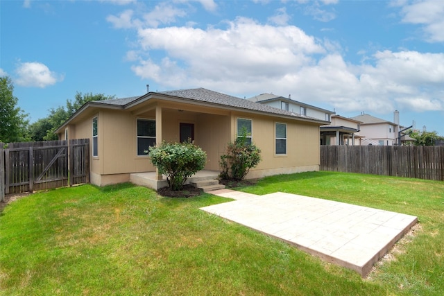 back of property with a patio and a yard