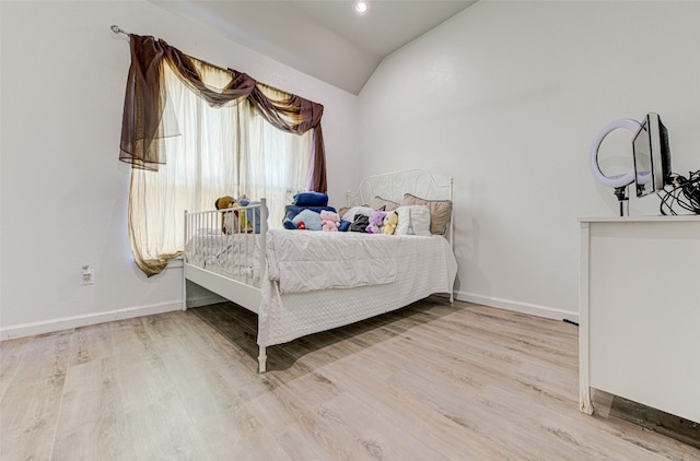 bedroom with vaulted ceiling and light hardwood / wood-style floors