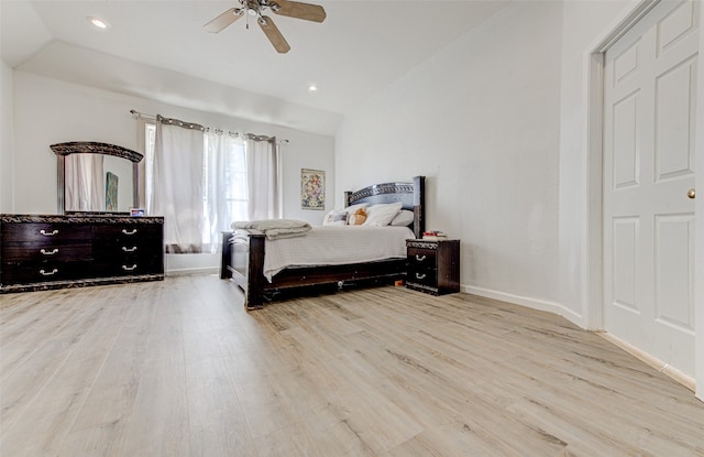 bedroom with ceiling fan, light hardwood / wood-style flooring, and vaulted ceiling