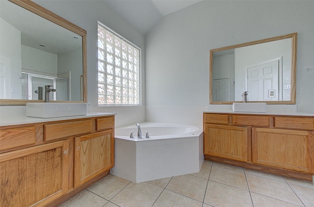 bathroom with vaulted ceiling, vanity, shower with separate bathtub, and tile patterned floors