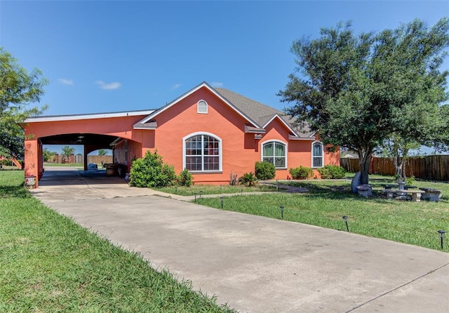 ranch-style house featuring a front lawn and a carport