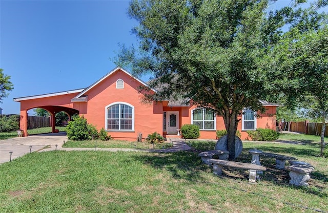 view of front of home with a carport and a front lawn