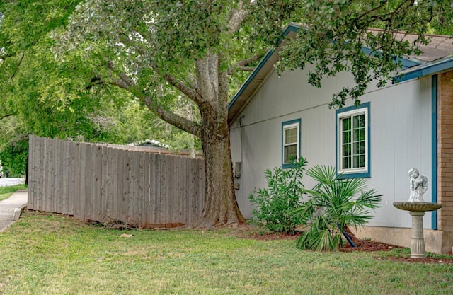 view of side of home with a yard