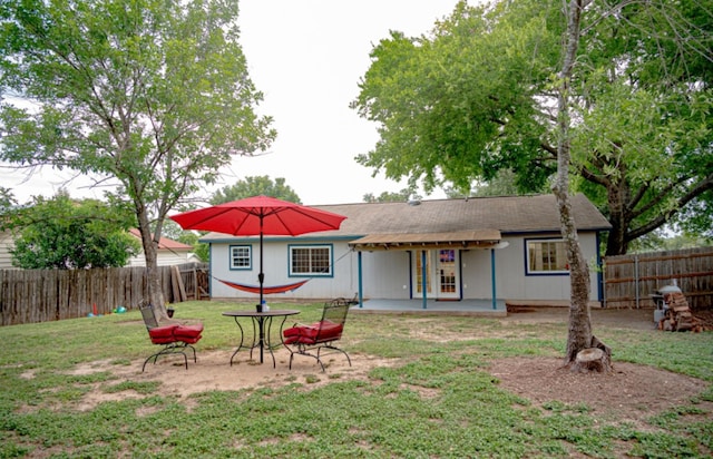 back of property with a yard and a patio