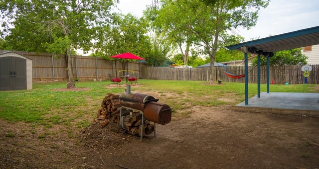 view of yard featuring a storage shed and a patio area