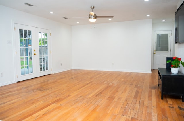 unfurnished room with ceiling fan, light wood-type flooring, and french doors