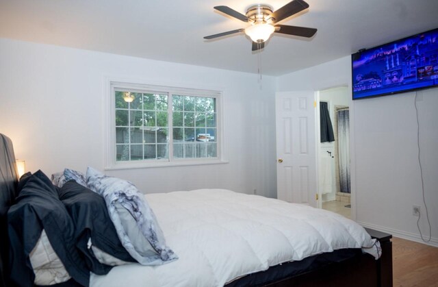 bedroom featuring wood-type flooring, ensuite bathroom, and ceiling fan