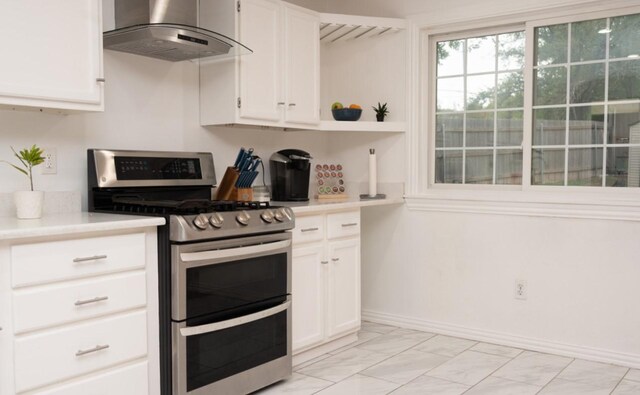 kitchen featuring white cabinetry, extractor fan, and range with two ovens