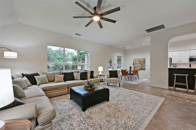 tiled living room featuring ceiling fan and vaulted ceiling