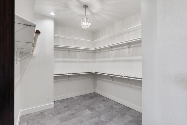 spacious closet featuring a chandelier