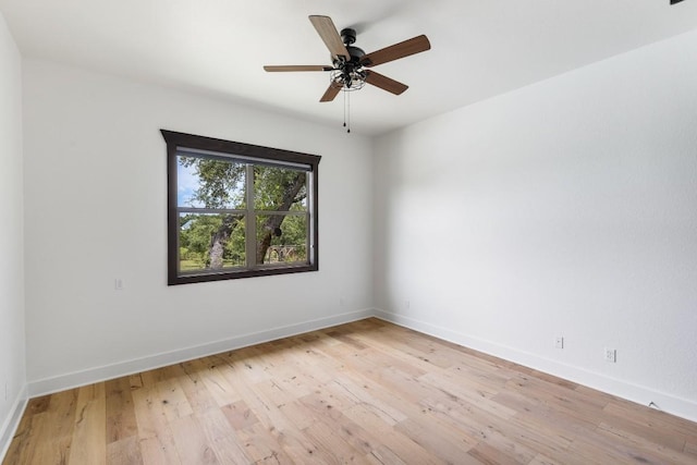 spare room with ceiling fan, light wood-type flooring, and baseboards