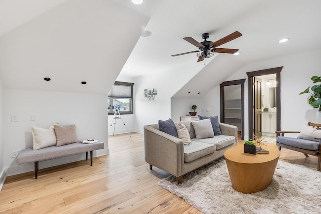 living room with baseboards, lofted ceiling, light wood-style flooring, and a ceiling fan