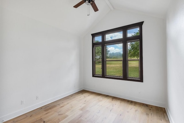 empty room featuring ceiling fan, vaulted ceiling with beams, light wood-type flooring, and baseboards