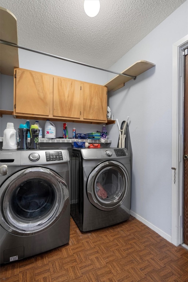 clothes washing area featuring cabinets, a textured ceiling, dark parquet floors, and independent washer and dryer