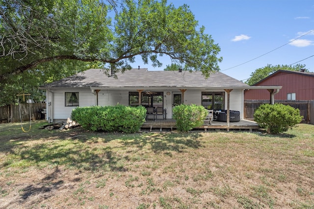 view of front facade with a wooden deck and a front lawn