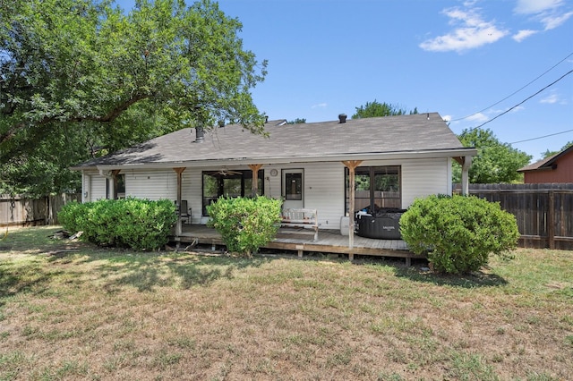 view of front of property with a deck and a front lawn