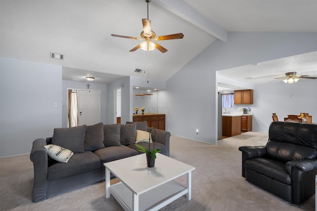 living room with lofted ceiling with beams, light colored carpet, a textured ceiling, and ceiling fan