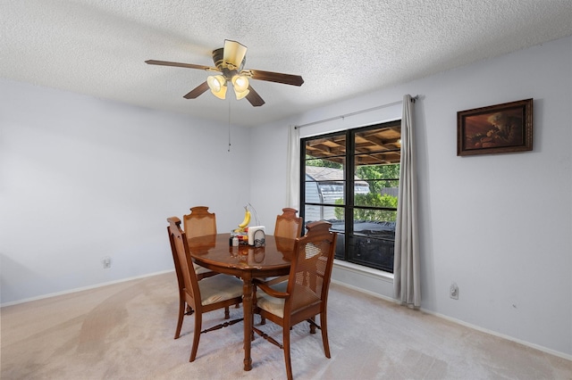 carpeted dining space with ceiling fan and a textured ceiling