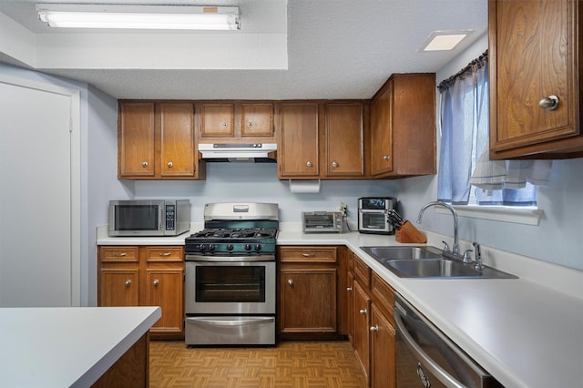 kitchen with sink, a textured ceiling, light parquet floors, and stainless steel appliances