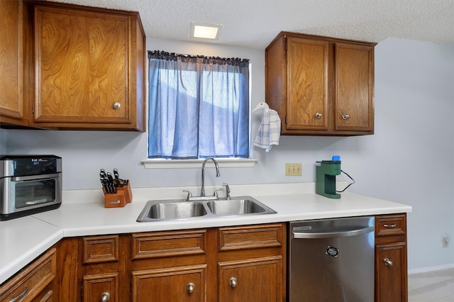 kitchen featuring sink, a textured ceiling, and dishwasher