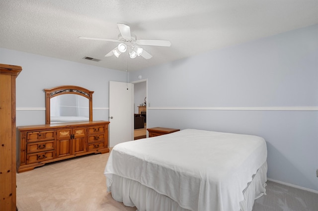 carpeted bedroom with ceiling fan and a textured ceiling