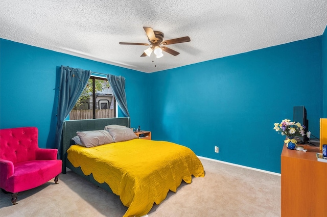 carpeted bedroom featuring ceiling fan and a textured ceiling