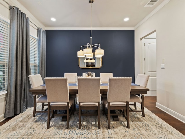 dining space featuring ornamental molding, visible vents, baseboards, and wood finished floors