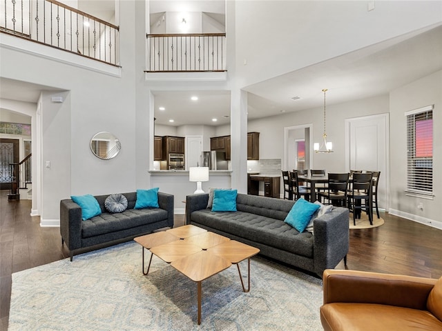 living room with baseboards, a high ceiling, stairway, and dark wood finished floors