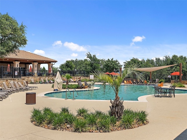 pool with a patio and fence