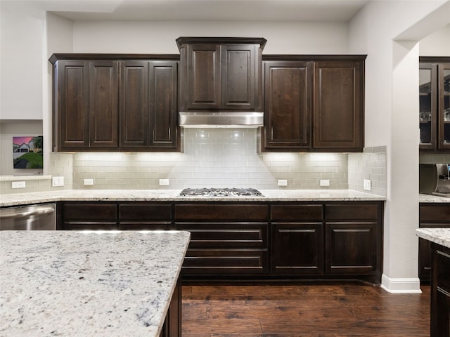 3417 Flat Iron Ct, Leander, TX 78641 - kitchen featuring stainless steel appliances, under cabinet range hood, dark wood-style floors, light stone countertops, and dark brown cabinetry