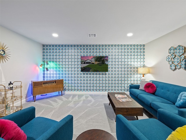 carpeted living area featuring wallpapered walls, baseboards, visible vents, an accent wall, and recessed lighting