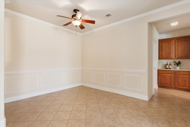 empty room featuring ornamental molding, light tile patterned floors, and ceiling fan