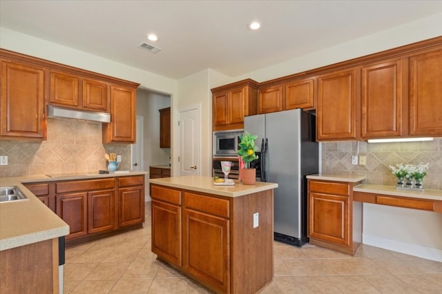 kitchen featuring decorative backsplash, stainless steel appliances, a center island, and light tile patterned floors