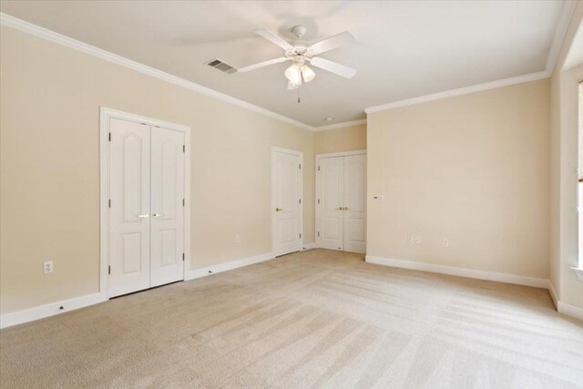 unfurnished bedroom featuring crown molding, light colored carpet, and ceiling fan