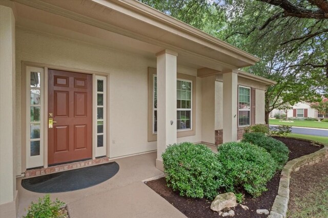 view of exterior entry featuring covered porch