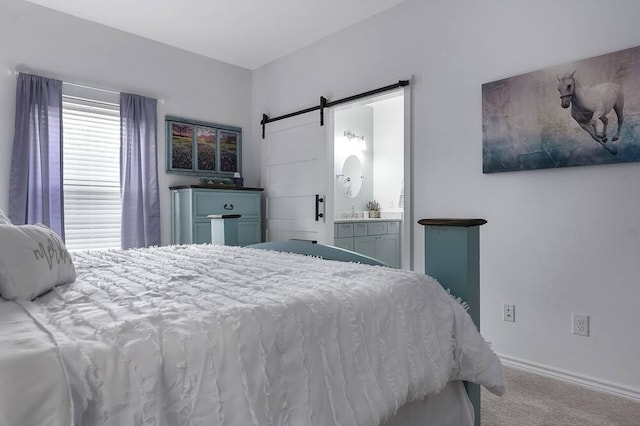 bedroom with a barn door, light carpet, and connected bathroom