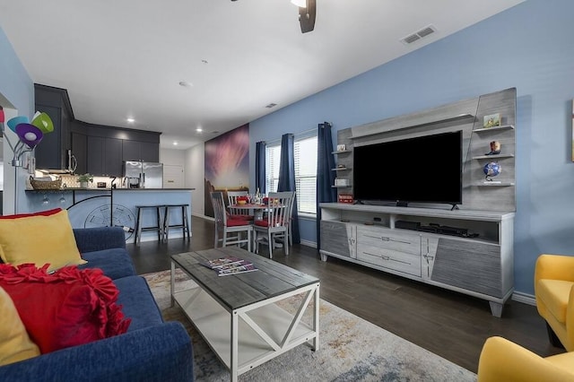 living room with ceiling fan and dark wood-type flooring