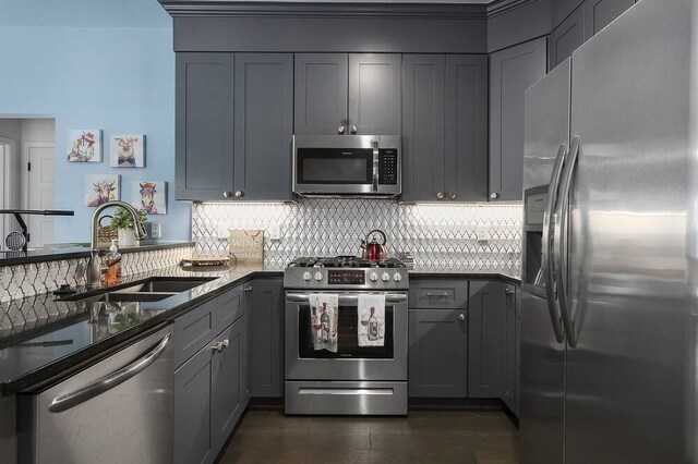 kitchen featuring gray cabinets, appliances with stainless steel finishes, tasteful backsplash, and sink