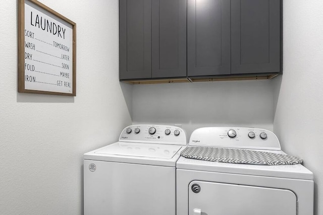 laundry room featuring washer and clothes dryer and cabinets