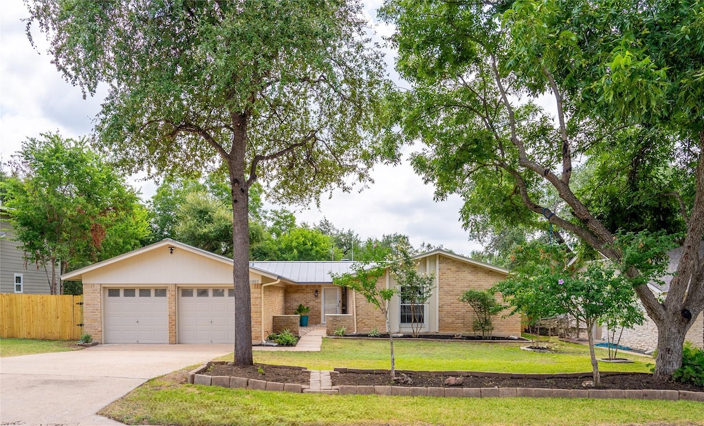 single story home with a garage and a front yard