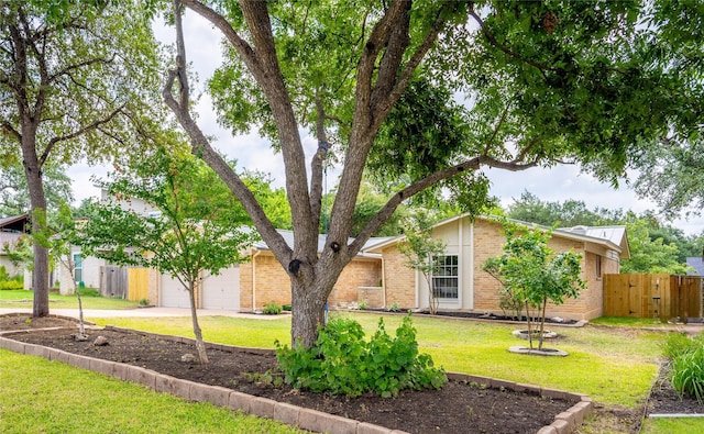 ranch-style home featuring a garage and a front lawn