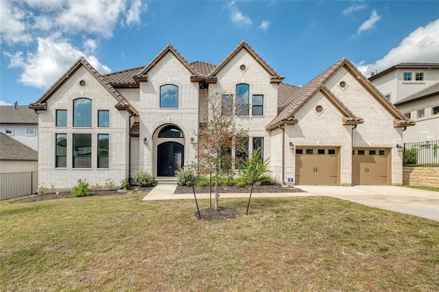 french country home with a garage and a front lawn