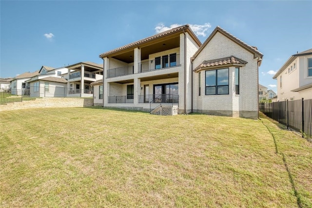 back of house with a balcony, a garage, and a lawn