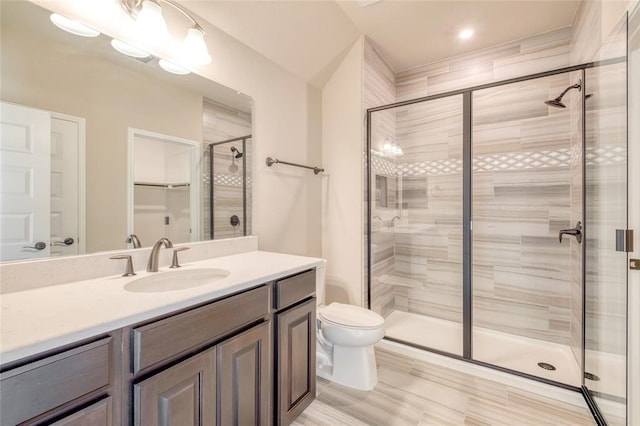 bathroom featuring toilet, vanity, and an enclosed shower