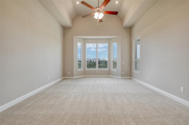 spare room featuring light carpet, high vaulted ceiling, and ceiling fan