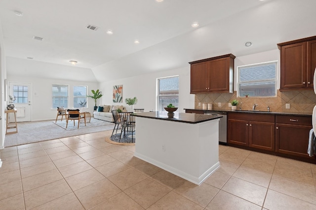 kitchen with dishwasher, sink, vaulted ceiling, and plenty of natural light