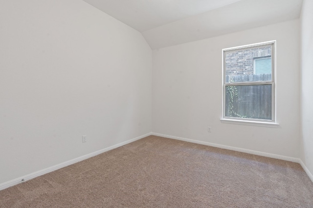 carpeted spare room with lofted ceiling