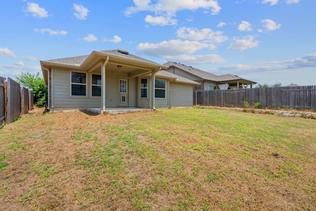 back of property with a lawn and a patio